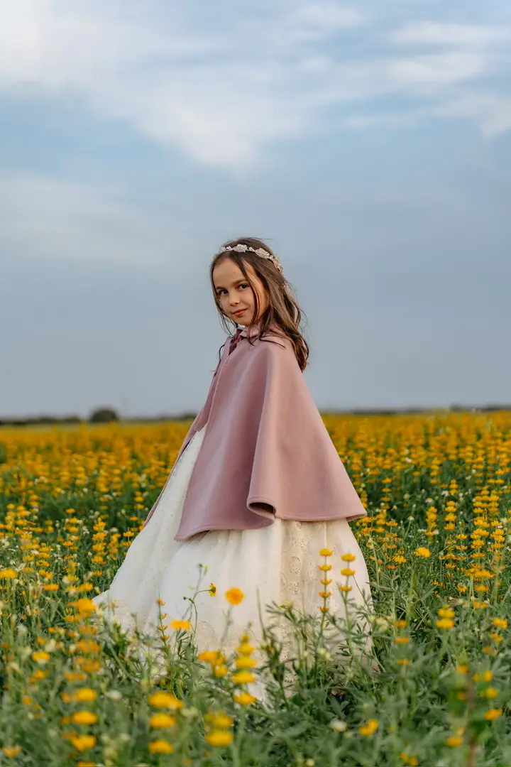 niña comunión con capa en campo