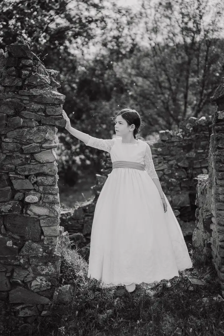 niña comunión posando en una fortaleza